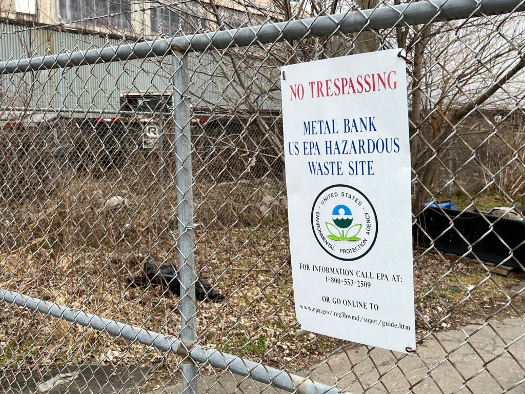 A "No Trespassing" sign leading to the former site of Metal Bank in Philadelphia is attached to a chain-link fence.