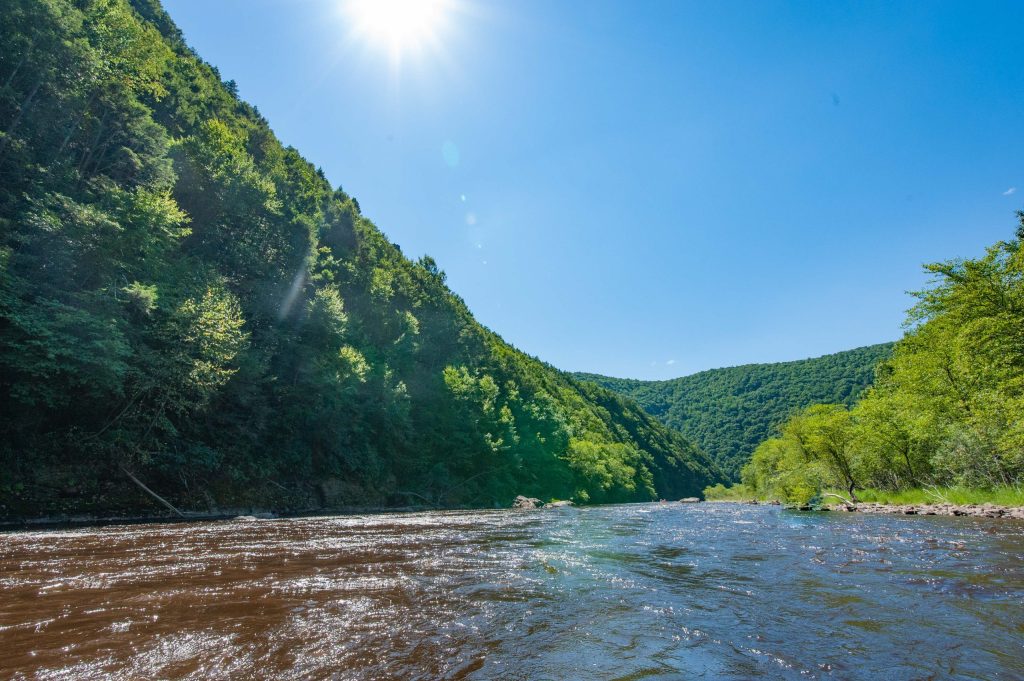 A scenic photo of the Lehigh River with a wedge of trees on either side.