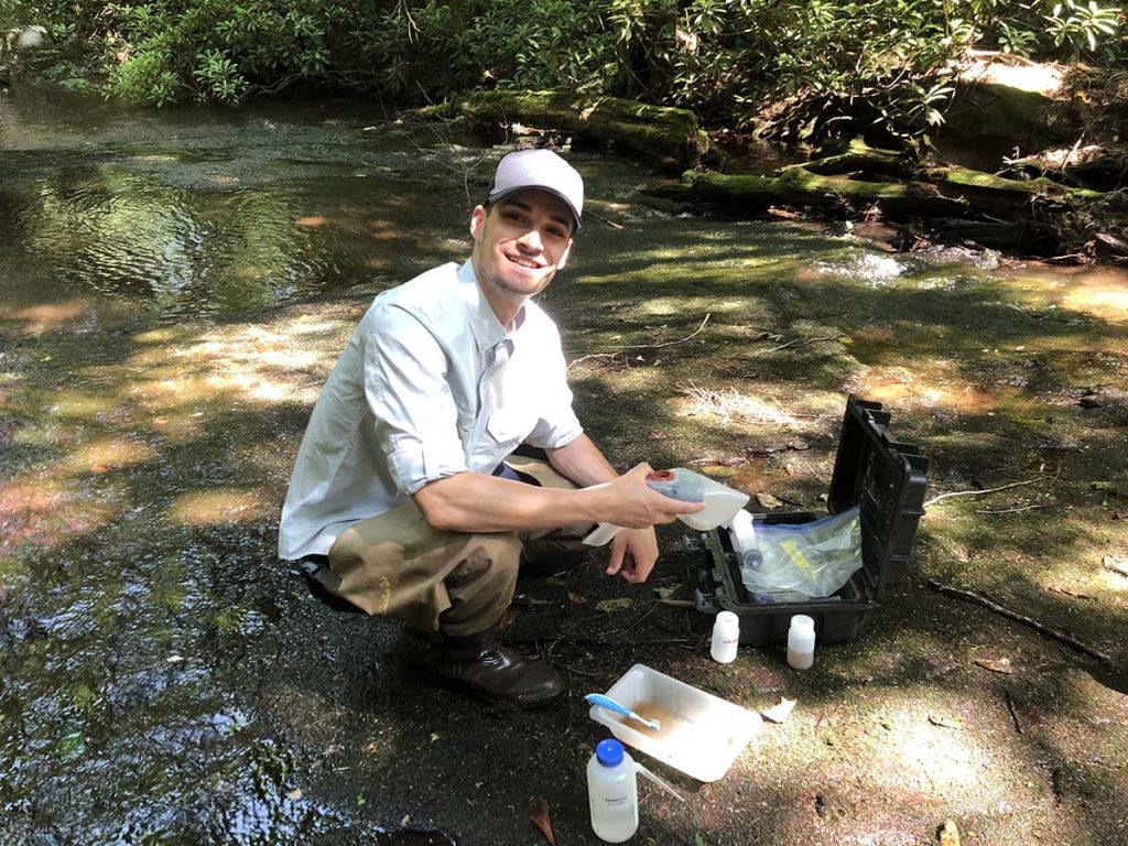 Mitch Liddick, Bloomsburg graduate student,  scraps algae off a rock for periphyton identification and analysis in 2021 at Kepers Run. PHOTO BY STEVEN RIER.
