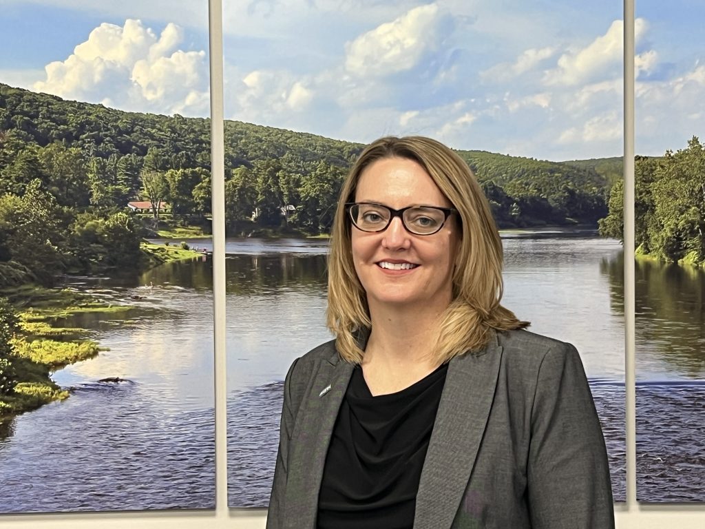 woman standing in front of photo of river