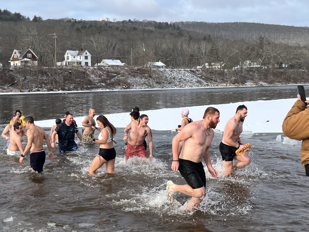 bunch of people running out of the river