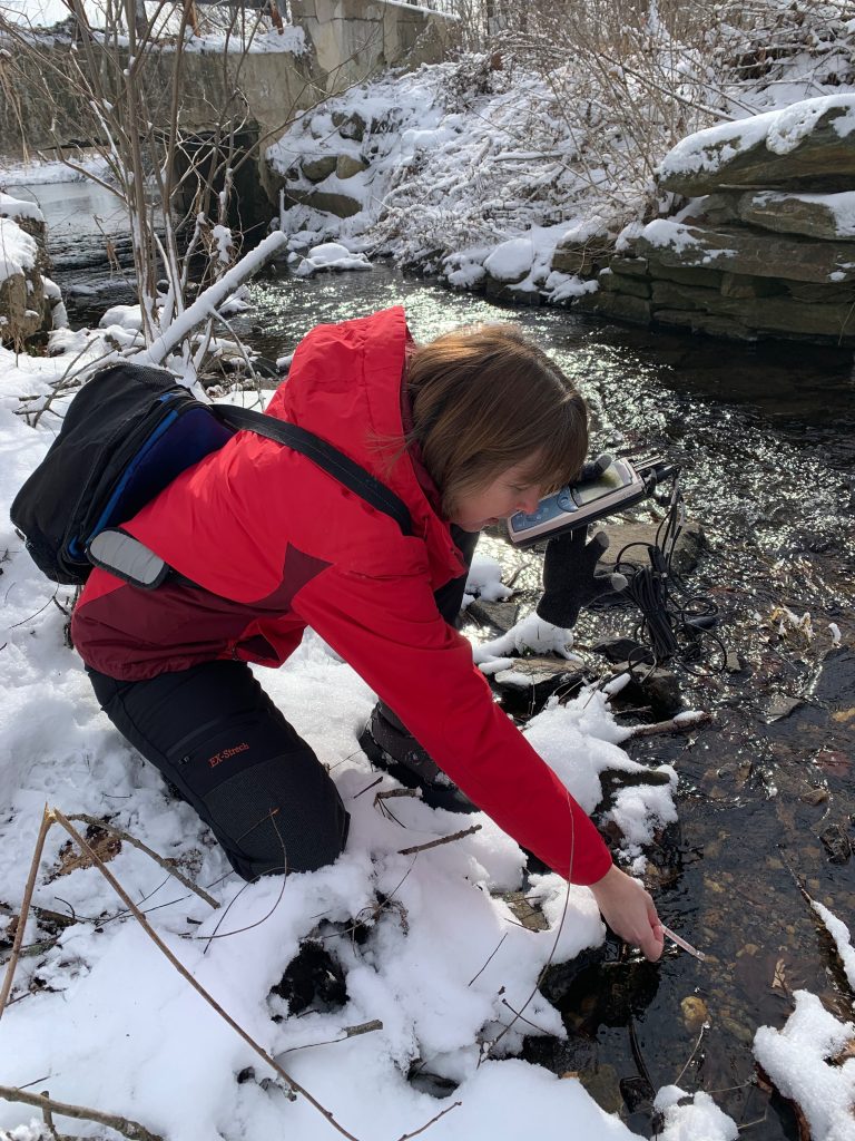 After a snowstorm in January 2025, Stroud Water Research Center scientist Jan Battle collects chloride and conductivity data from the East Branch of White Clay Creek, a Chester County stream in the Delaware River watershed. Photo: Stroud Water Research Center
