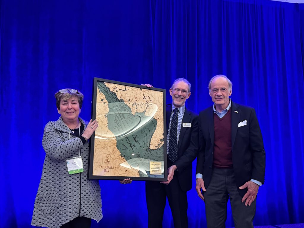 Kathy Klein, executive director of the Partnership for the Delaware Estuary; Christophe Tulou, executive director of the Center for the Inland Bays; and former U.S. Senator Tom Carper, who was presented a framed wooden carving of the Delaware Bay as a thank you for his years of support.

