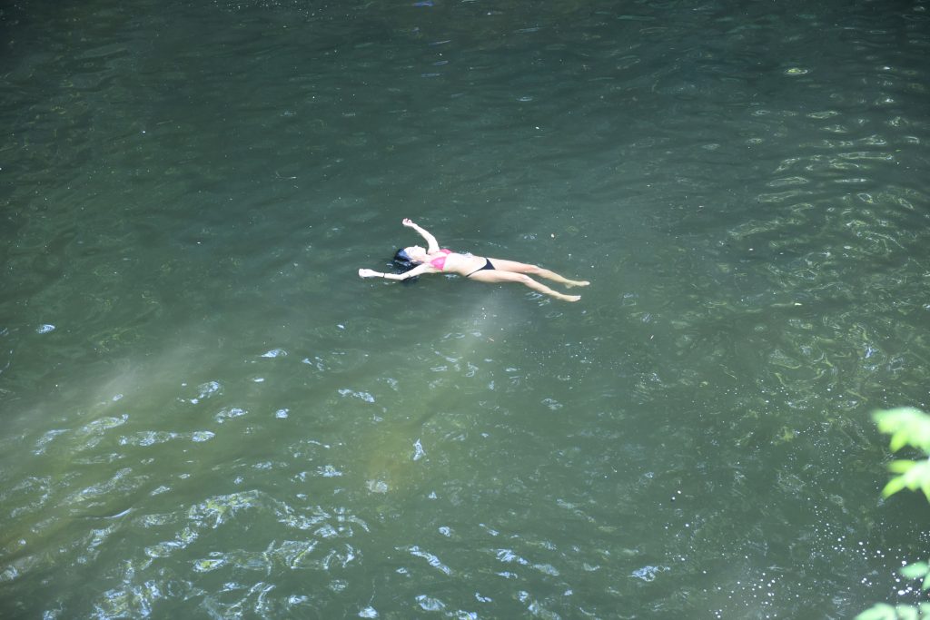 Woman floating in creek.