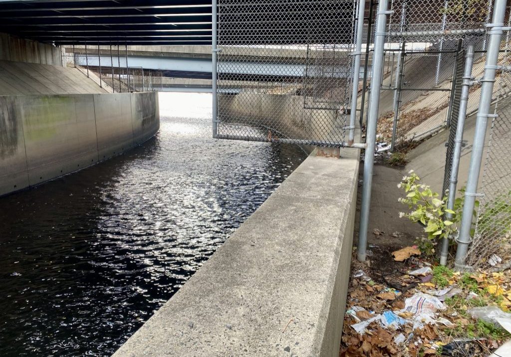 The Assunpink Creek on its its way to meet the Delaware River. The creek passes through woods, industrial and commercial areas and spots both sparkling and filled with litter. 