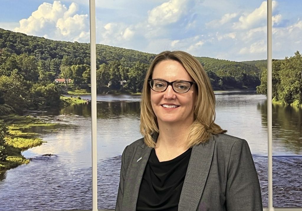 woman standing in front of photo of river