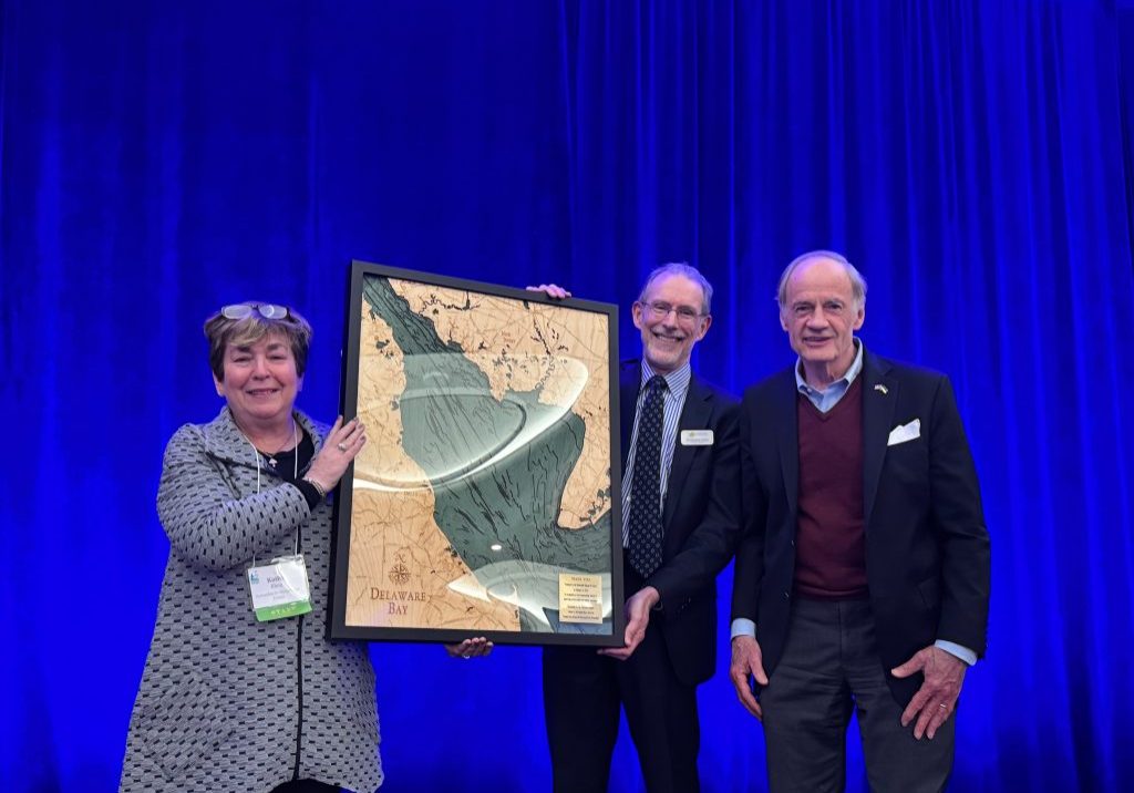 Kathy Klein, executive director of the Partnership for the Delaware Estuary; Christophe Tulou, executive director of the Center for the Inland Bays; and former U.S. Senator Tom Carper, who was presented a framed wooden carving of the Delaware Bay as a thank you for his years of support.

